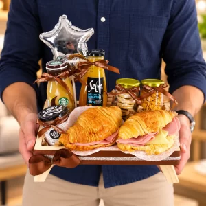 Desayuno Sweet King en bandeja de madera con croissants y bebidas
