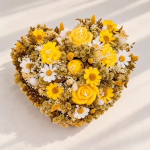 Composición floral amarilla y blanca con velas artesanales en forma de flores