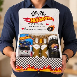 Mr. Box abierto con tres carros Hot Wheels, dos cervezas Candelaria, papas nativas y chocotejas